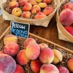 boxes of peaches with a sign saying yellow peaches 3.99/lb