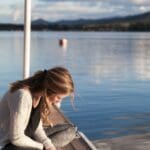 lady sitting next to the water 