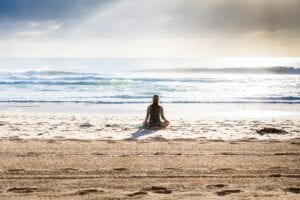 lady sitting in the ocean meditating