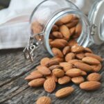 almonds in a glass jar spilling out 